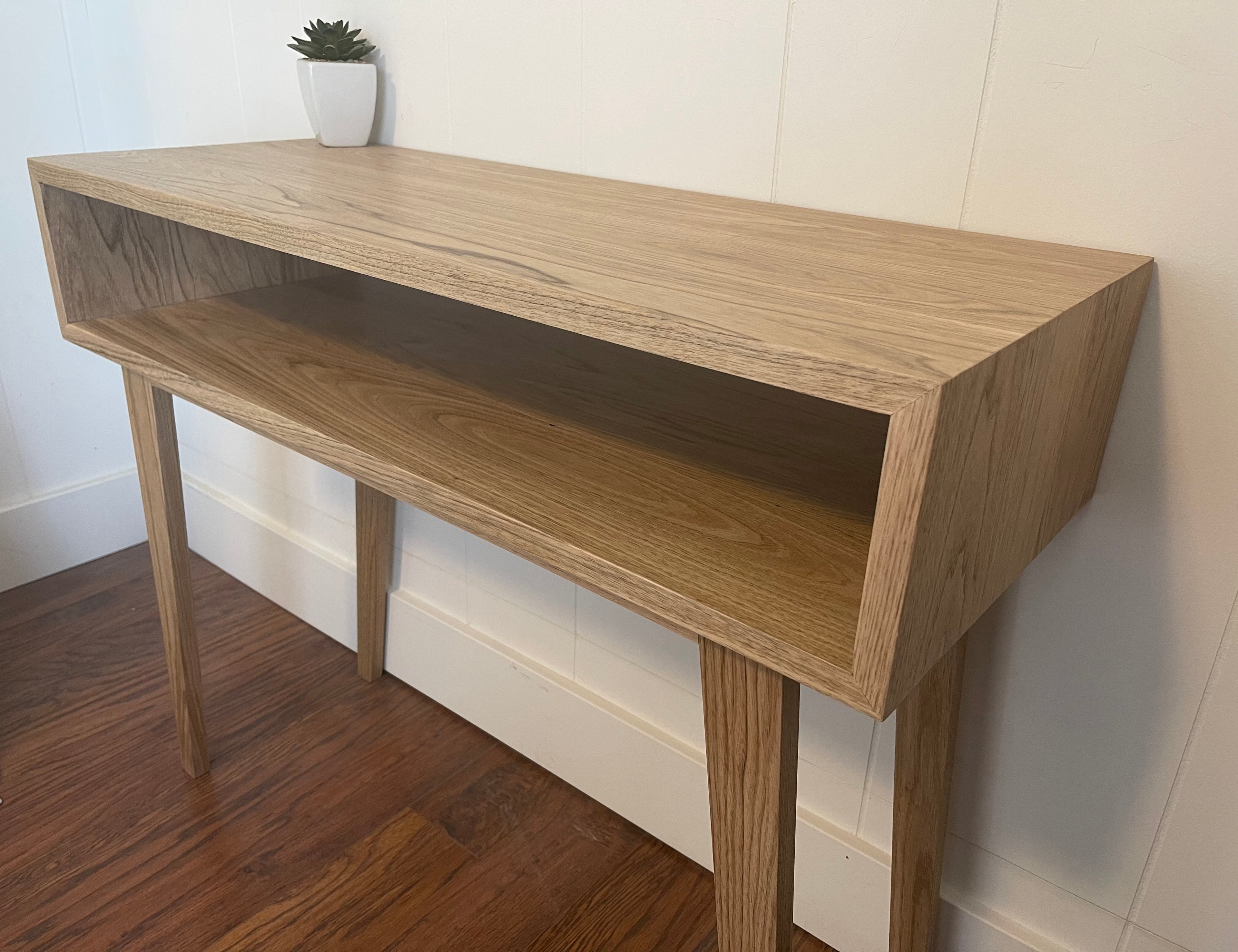 A picture of a custom made mid-century modern desk.  The desk is made out of butternut wood.  This is a gentle, creamy colored wood.